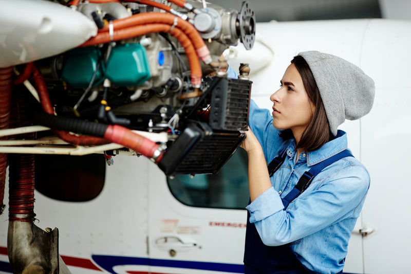 Joven mujer lava el motor de un avión